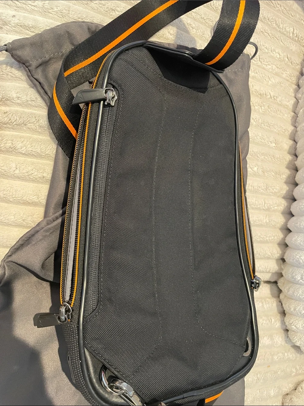 Tumi Black Sling Bag with Orange Accents